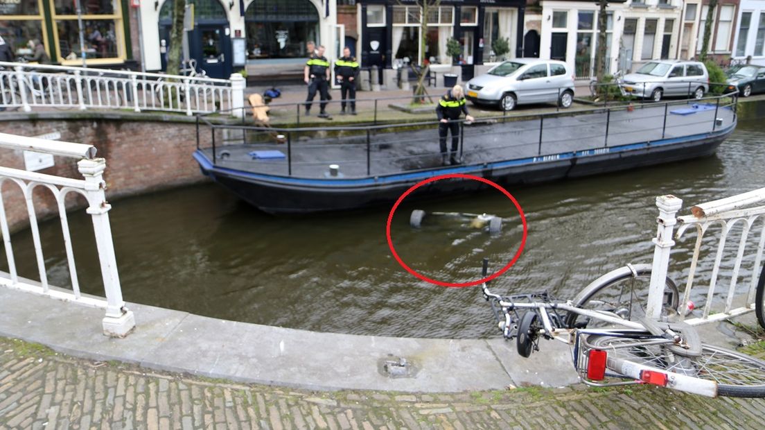 De auto reed door het hek en ging kopje onder in de Oude Delft 