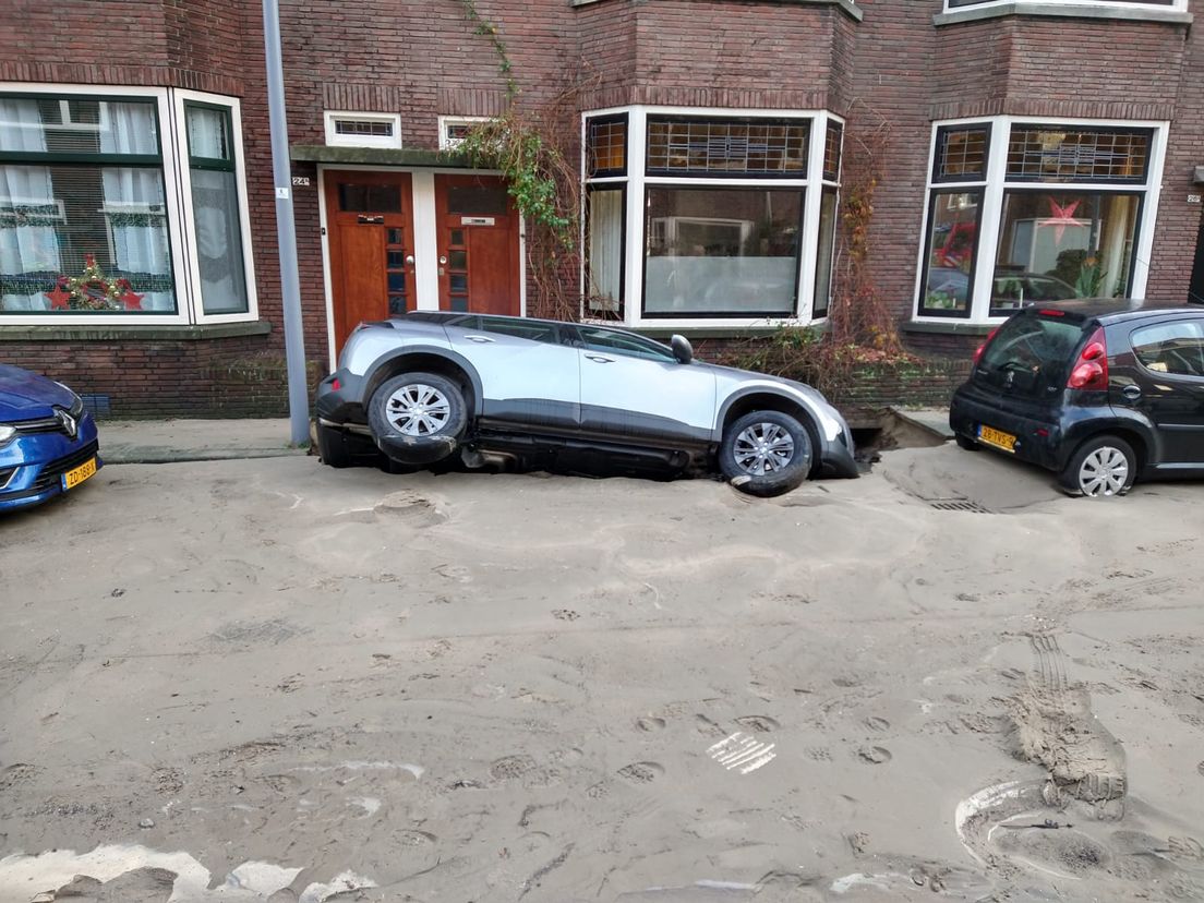De auto ligt grotendeels  in een sinkhole