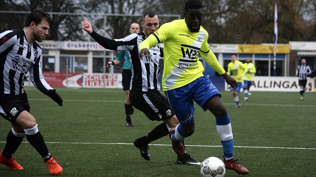 Daniel Akindayini in duel met twee spelers van Zwaluwen