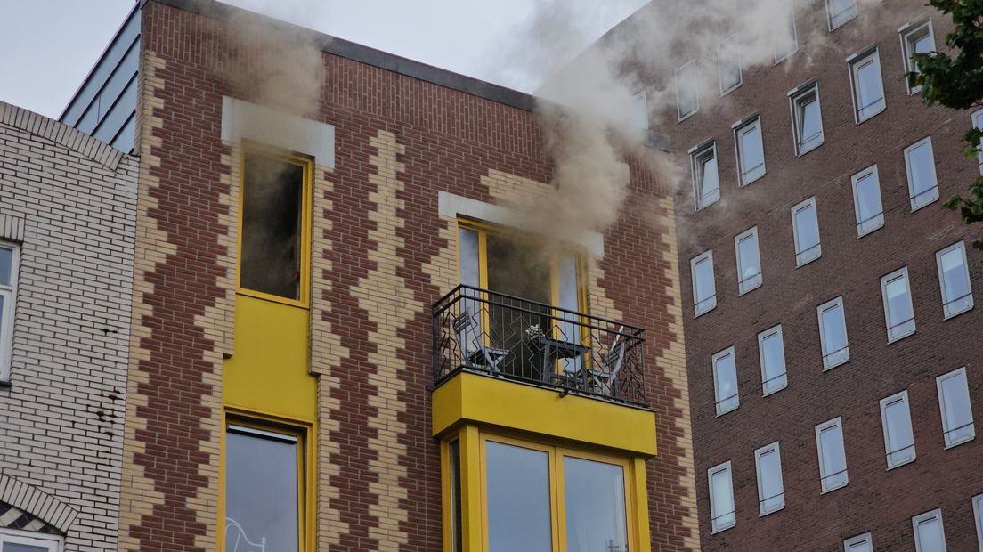 Rook ontsnapt uit de ramen van de bovenwoning aan De Brink Oosterhaven in Groningen