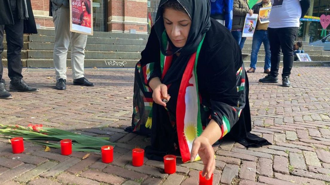 Dieman Ahmadi steekt een kaarsje aan voor de overleden vrouw (22) uit Iran.