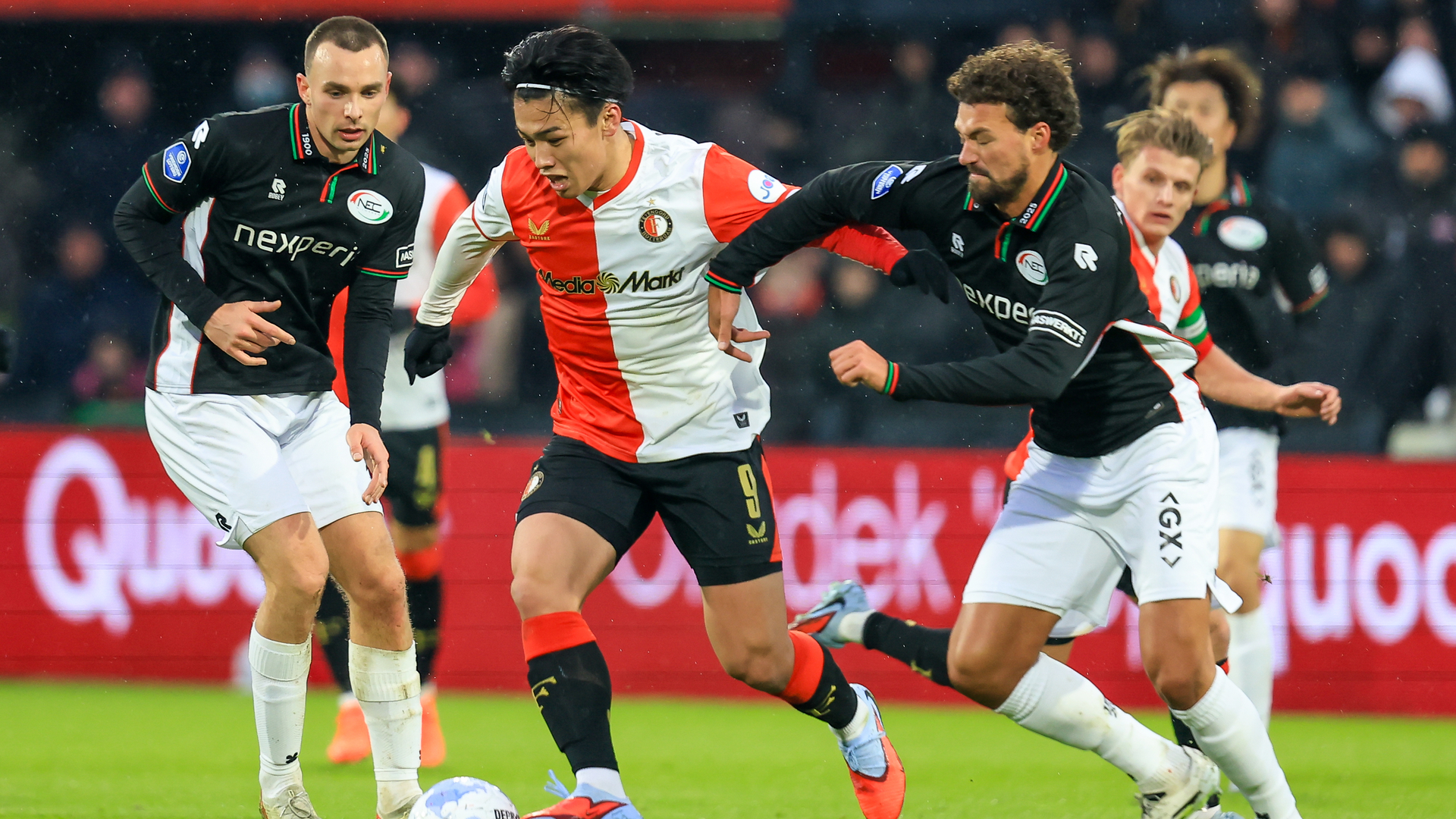 Ayase Ueda in duel met ex-Feyenoorder Philippe Sandler tijdens de thuiswedstrijd tegen NEC.