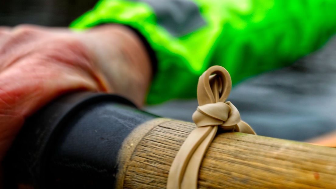 Een dik elastiek met een knoop geeft de stand van de peddel aan