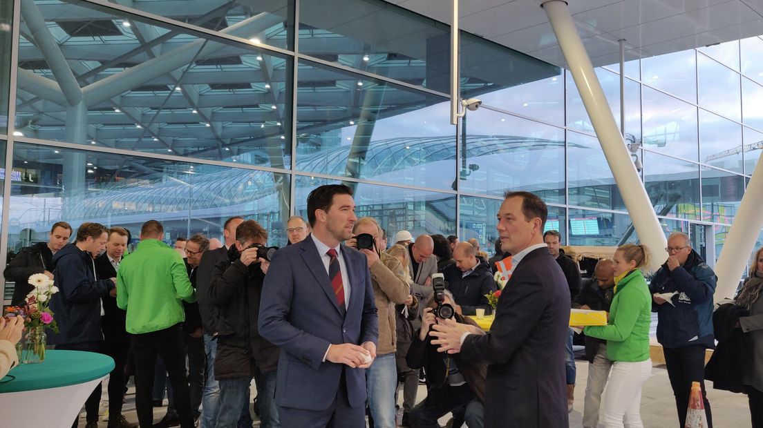 De wethouder Robert van Asten en Boudewijn Revis (rechts) nemen de overkapping van het busplatform in gebruik.