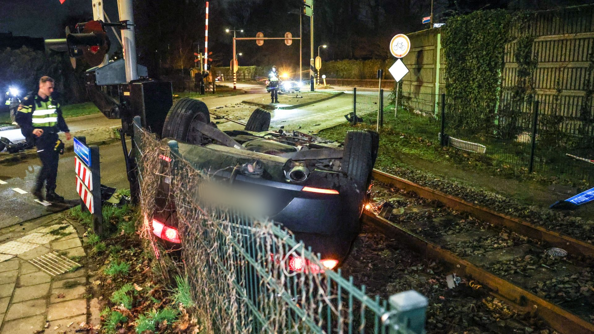 Chaos bij spoorwegovergang: auto slaat meerdere keren over de kop, bestuurder gevlucht