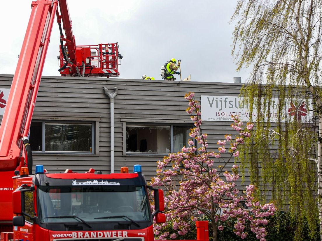 De brandweer inspecteert het dak van het bedrijfsverzamelgebouw nadat het vuur onder controle is