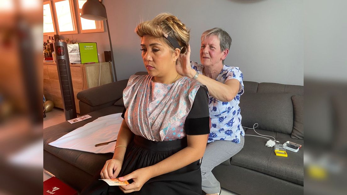 Mieke Gubbels van Stichting Zeeuwse Klederdracht helpt de bruid met haren opsteken