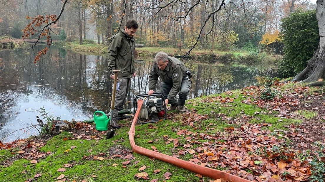 Medewerkers van Natuurmonumenten pompen water in de boom