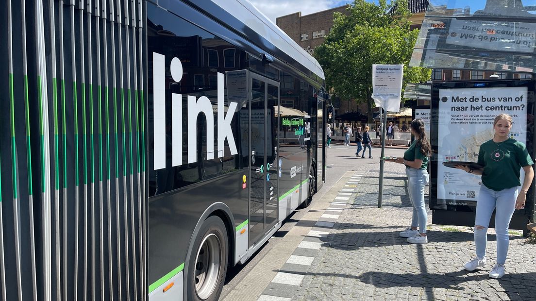 Promotiemedewerkers delen chocolaatjes en plattegronden uit aan busreizigers