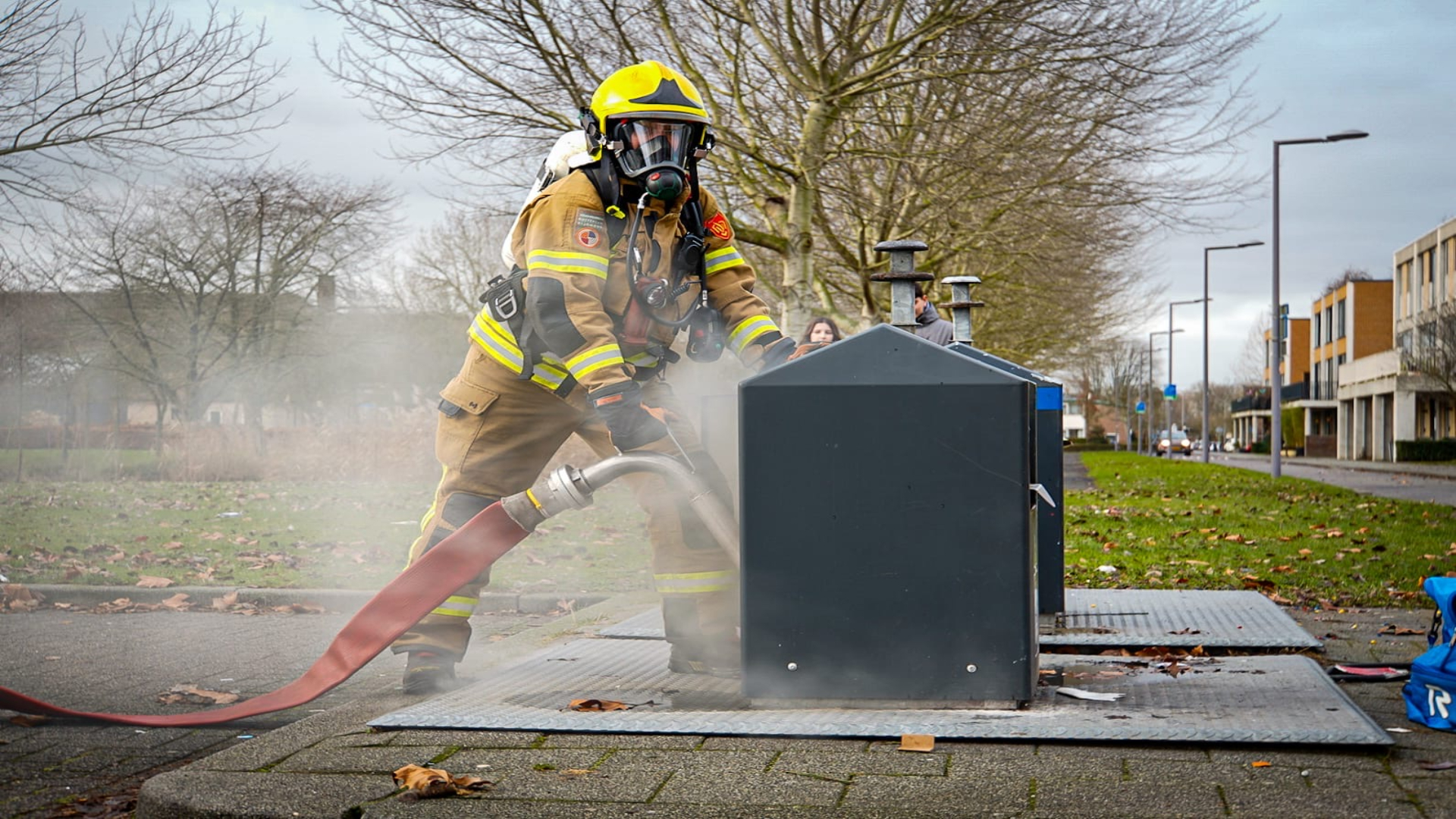 Brandweer blust brand in afvalcontainer