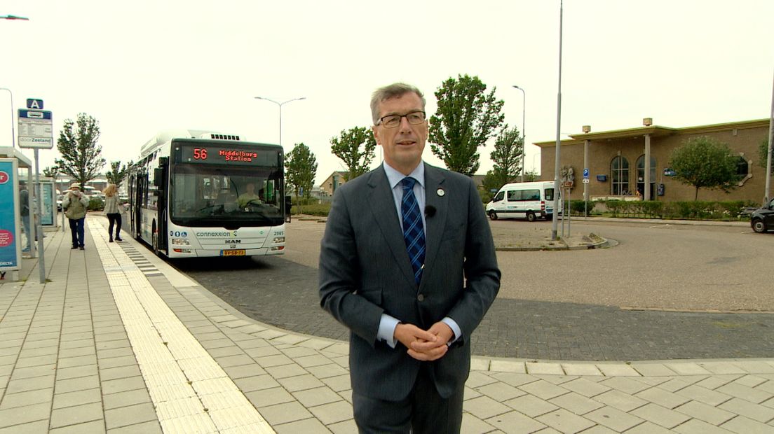 Wethouder John de Jonge (LPV) op het Stationplein - op de achtergrond de bus naar Middelburg