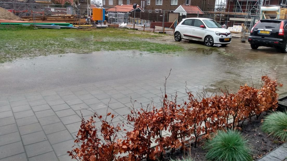 Bij zware regenval staat het grasveld, waar de bewoners normaal parkeren, blank.