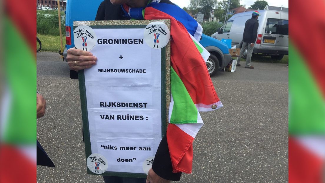 Een demonstrant met een protestbord tijdens het bezoek van Rutte
