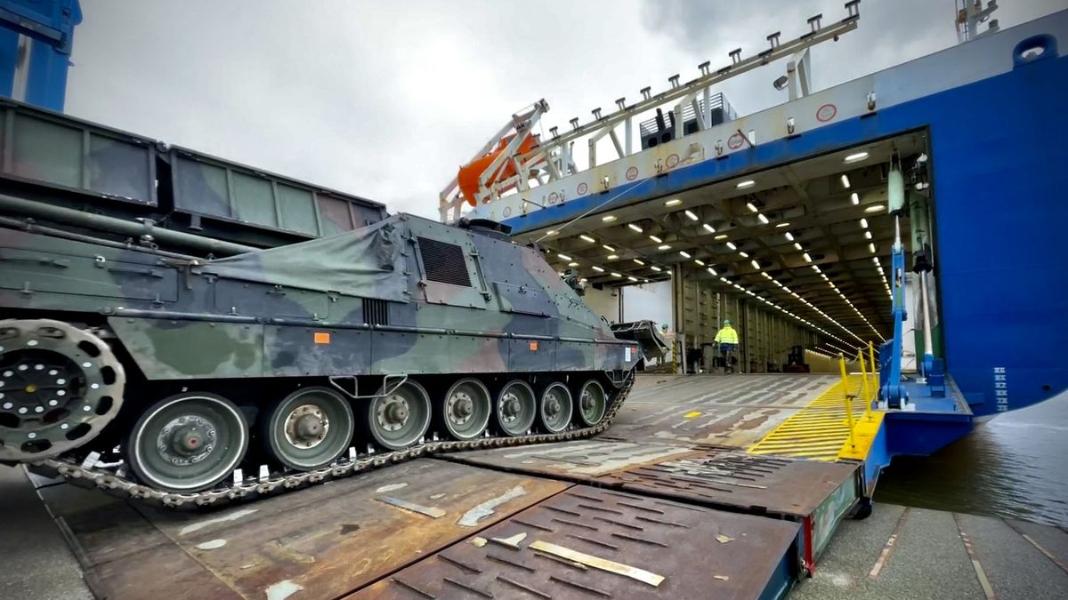 Military vehicles being transported on a highway, illustrating the scale of logistics and infrastructure that Trimble's technology supports in sectors like transportation and defense.