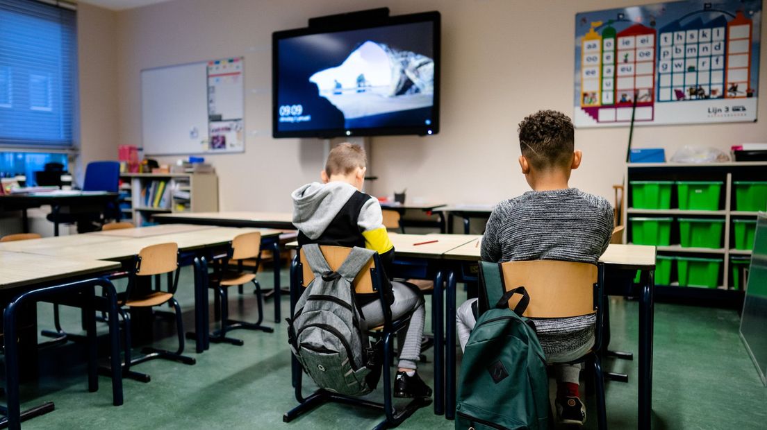 Kinderen op een basisschool voor de noodopvang.