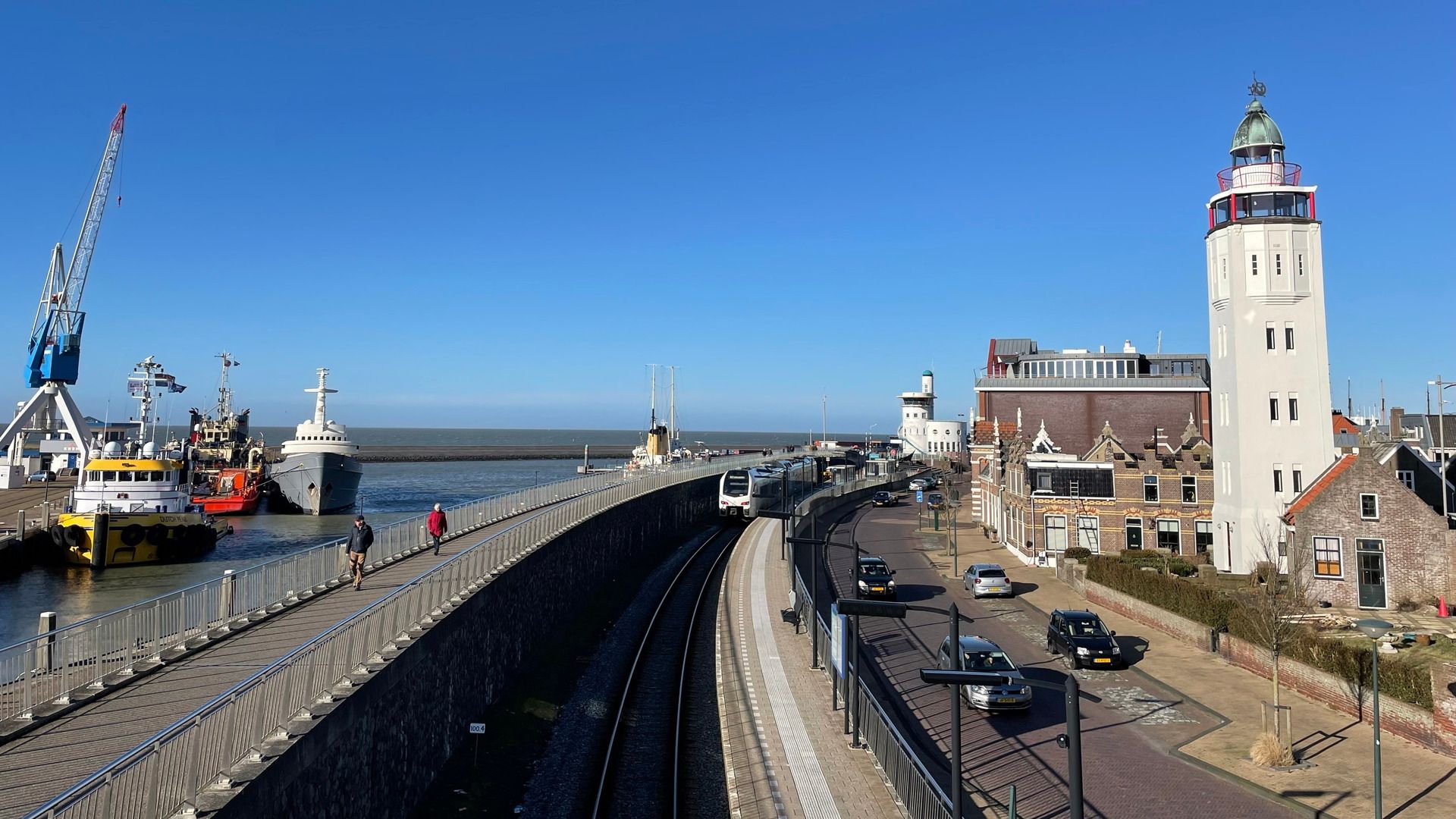 Het station bij de haven van Harlingen met de vuurtoren van Harlingen