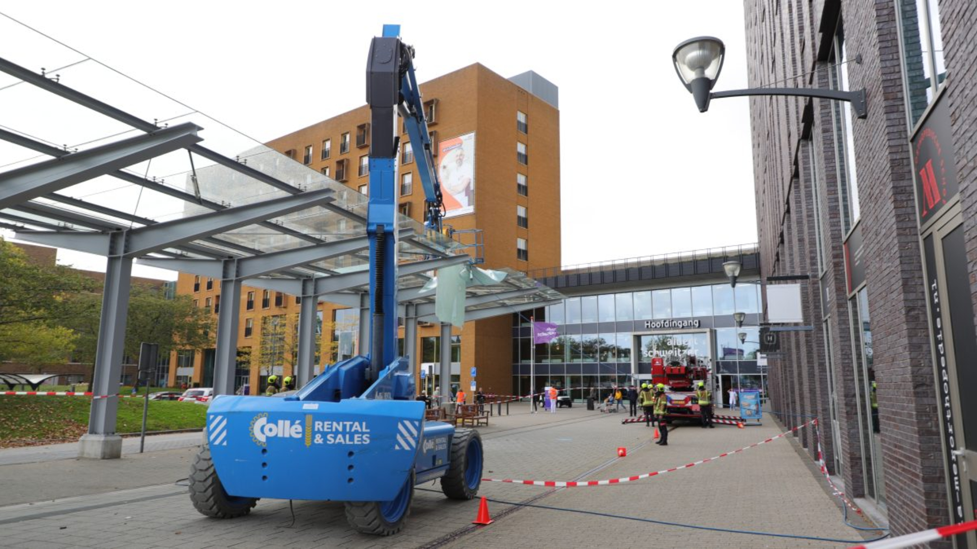 De hoogwerker viel na de klap tegen de glazen overkapping uit, waarna de medewerker vast kwam te zitten.