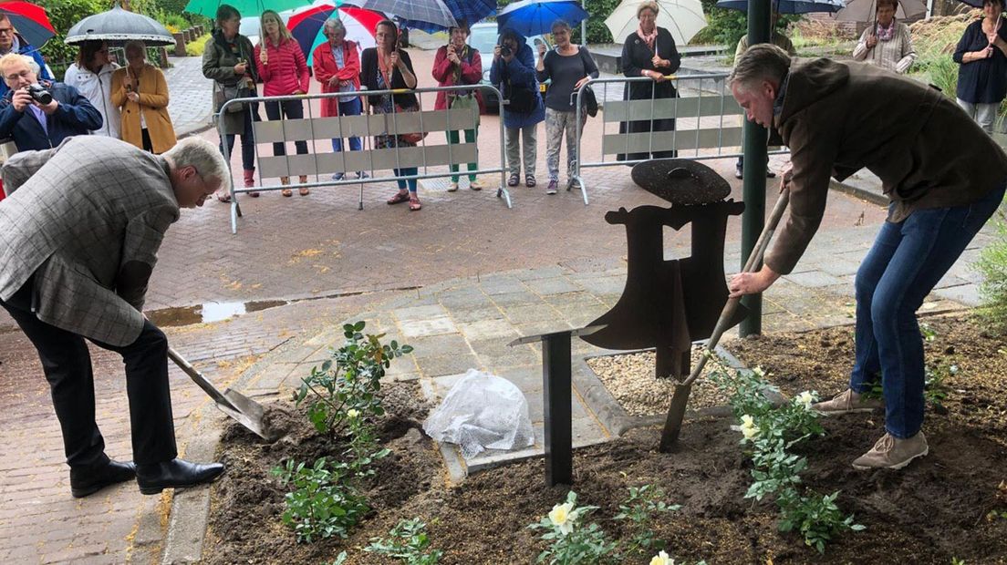 Wethouder Kees Swagerman (links) en Erik Hulsegge planten een roos