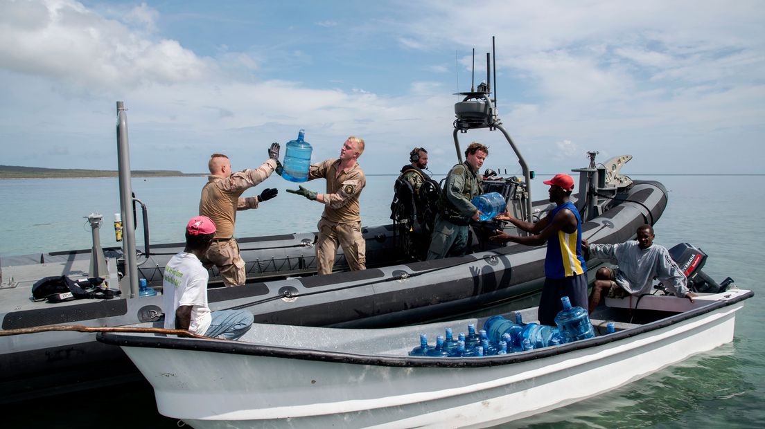 De militairen geven jerrycans met drinkwater aan lokale vissers (Rechten: defensie)