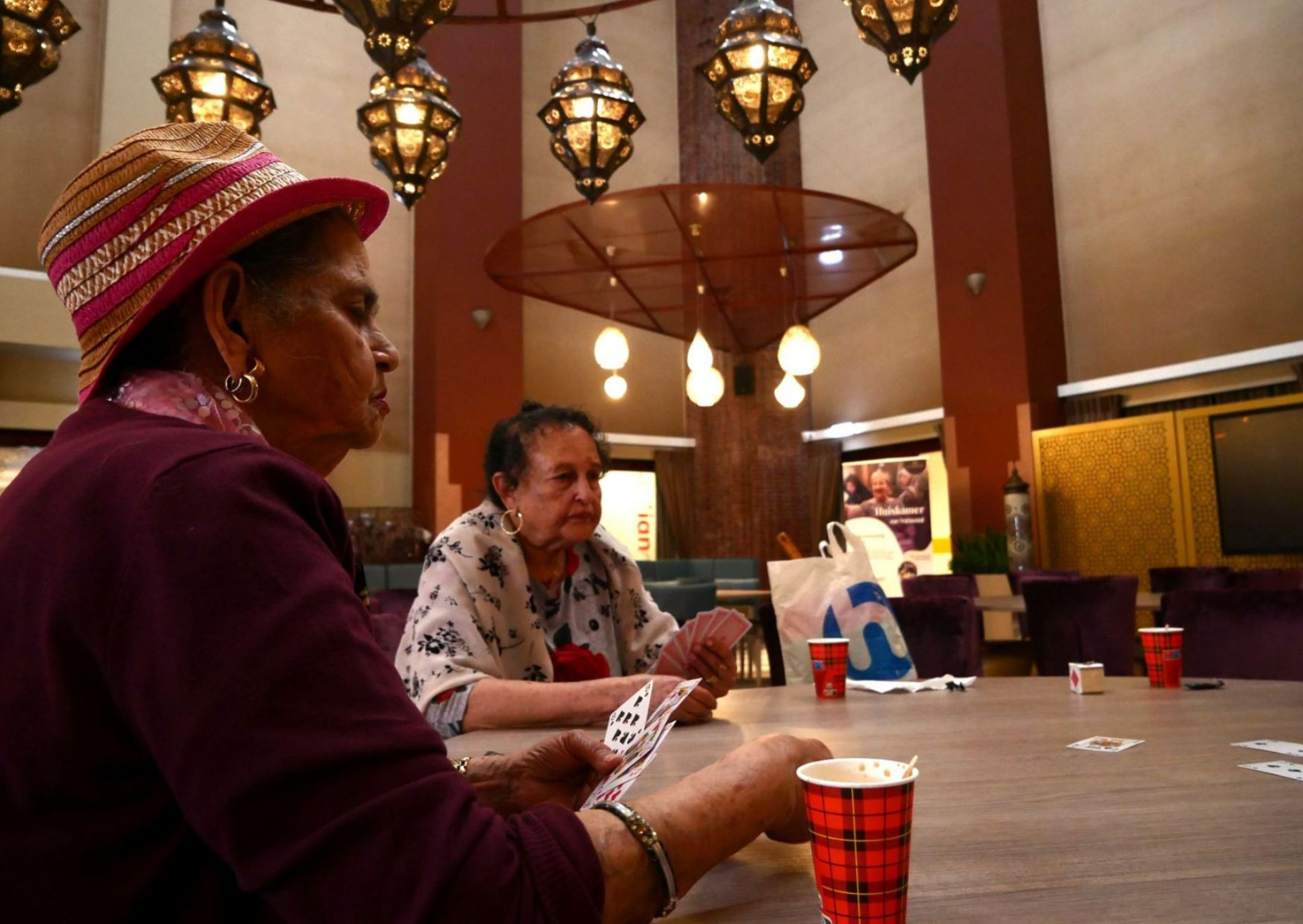 Ouderen in het Seniorencafé spelen het Surinaamse troefcall