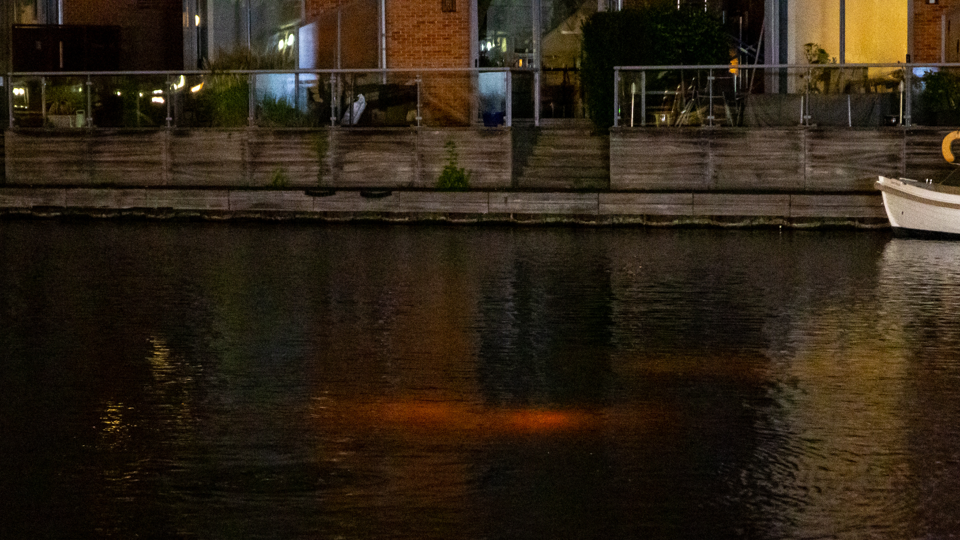 De gezonken auto, met nog brandende verlichting
