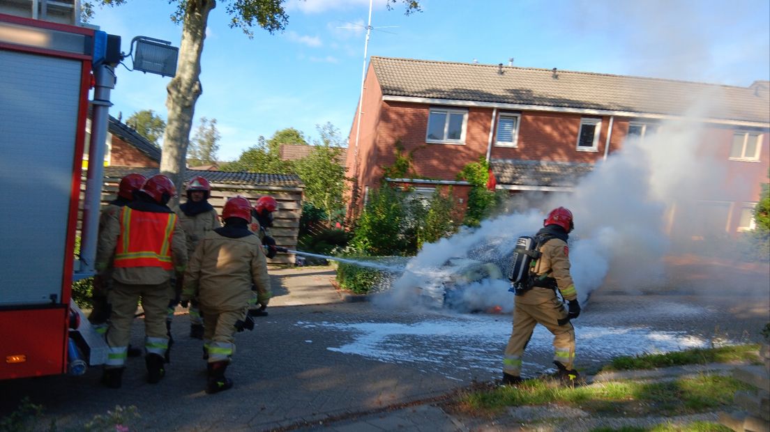 Brandweer blust brandende auto