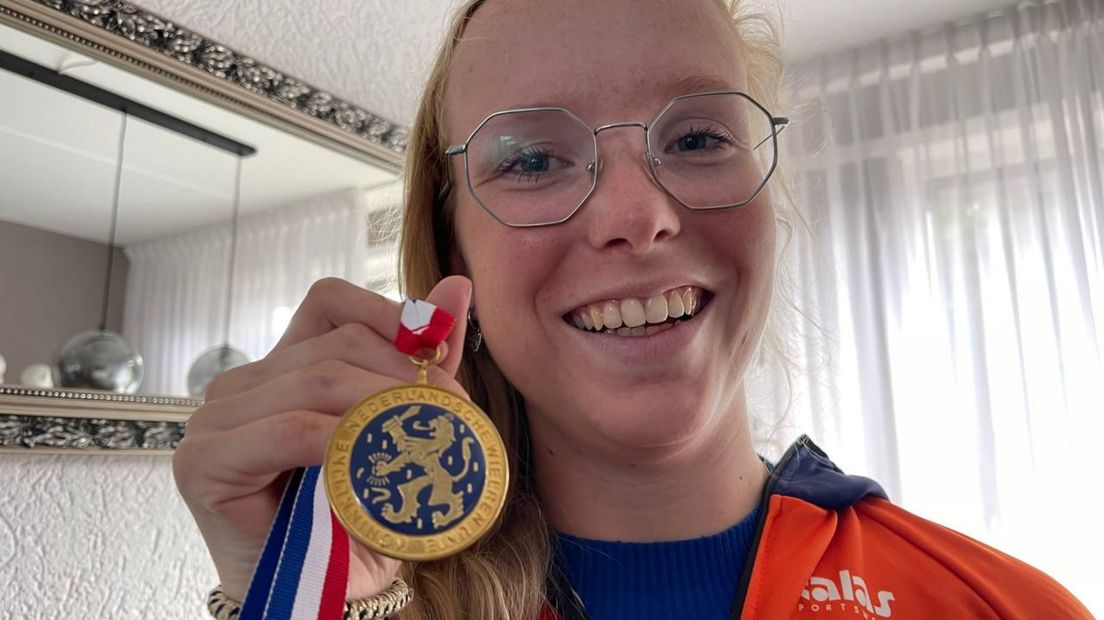 Melanie Helweg toont de medaille die ze kreeg na haar NK-winst