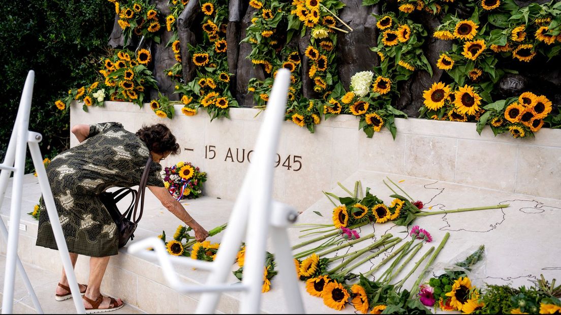 Vrouw legt bloemen bij Indiëmonument