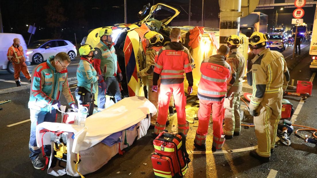 Een ambulance is op z'n kant terecht gekomen na een aanrijding met een personenauto.