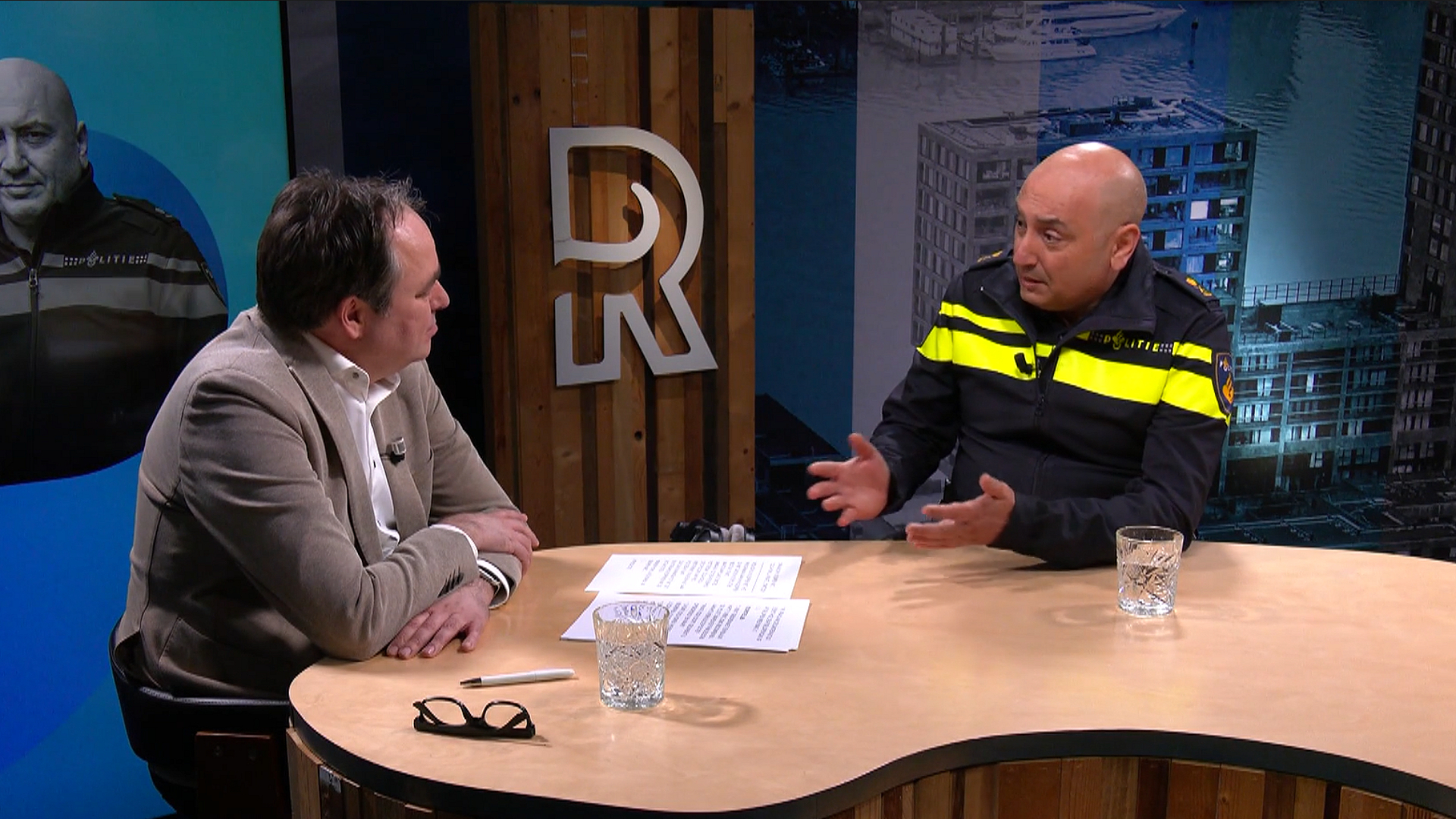 Politiechef Tolga Koklu in gesprek met presentator Ruud de Boer op TV Rijnmond.