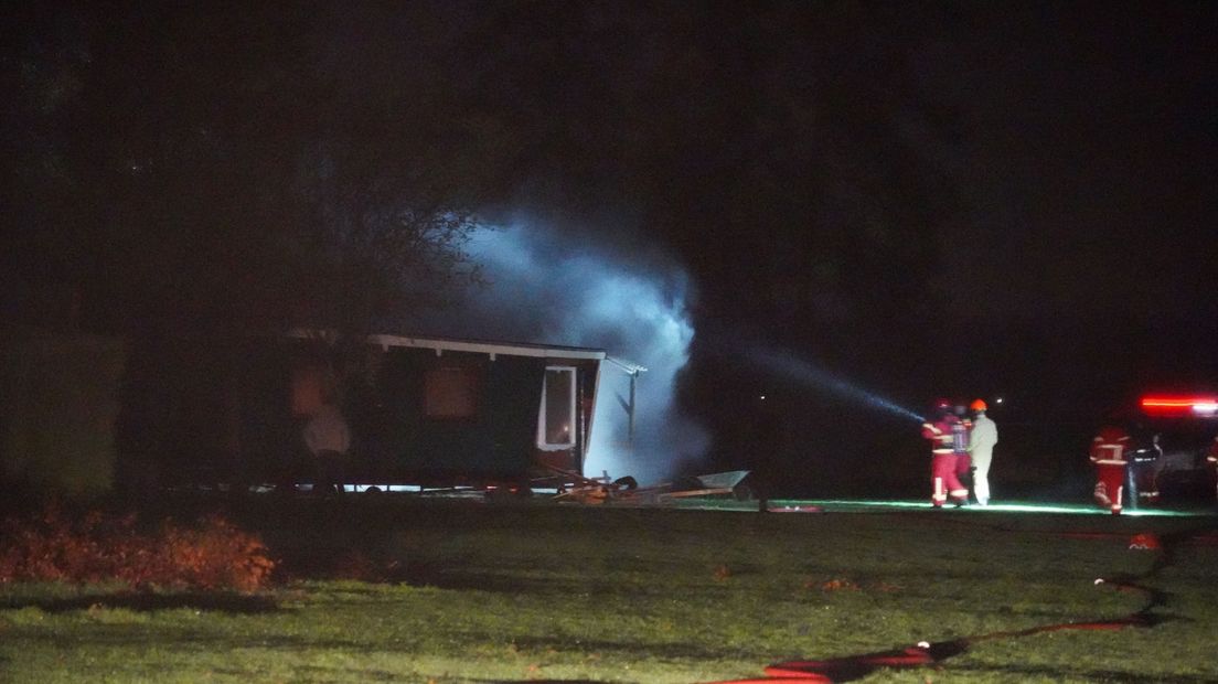 De brandweer blust het vuur in de schuur
