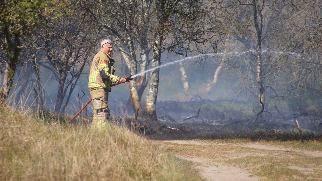 Een van de eerste aanwezige brandweerlieden probeert het vuur te blussen