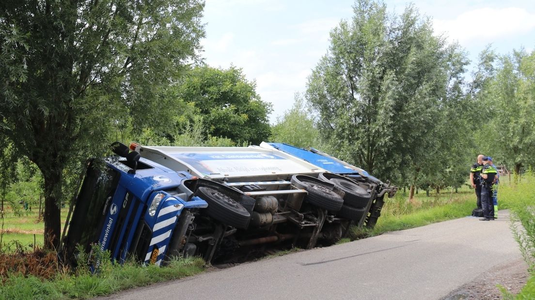 Vuilniswagen kantelt de berm in