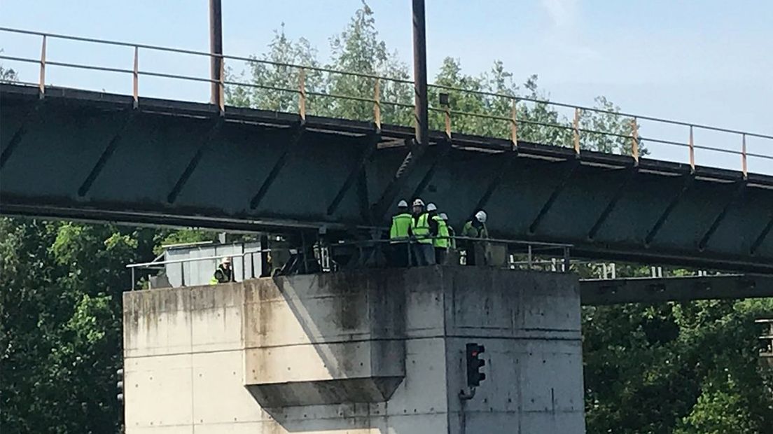 Onderzoekers bekijken de schade rond de spoorbrug