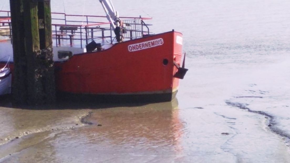 De veerboot De Onderneming komt klem te zitten bij laag water bij de haven van Perkpolder