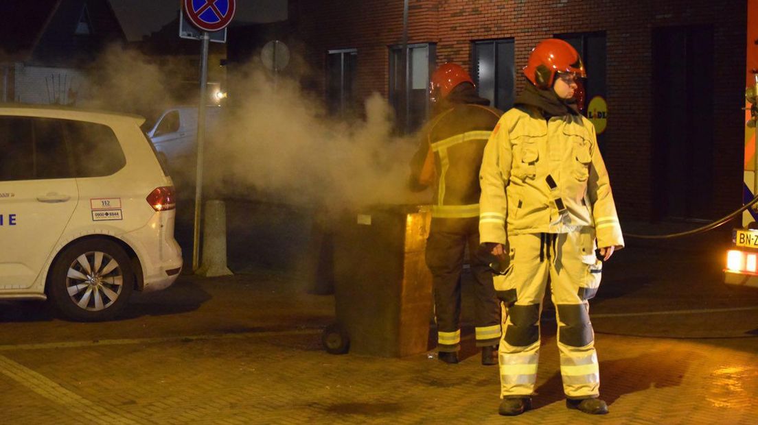 De brandweer blust een grijze container in Hoogkerk