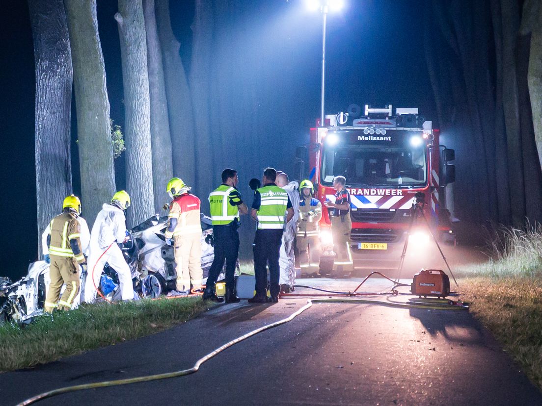 De hulpdiensten zijn druk bezig bij de uitgebrande auto