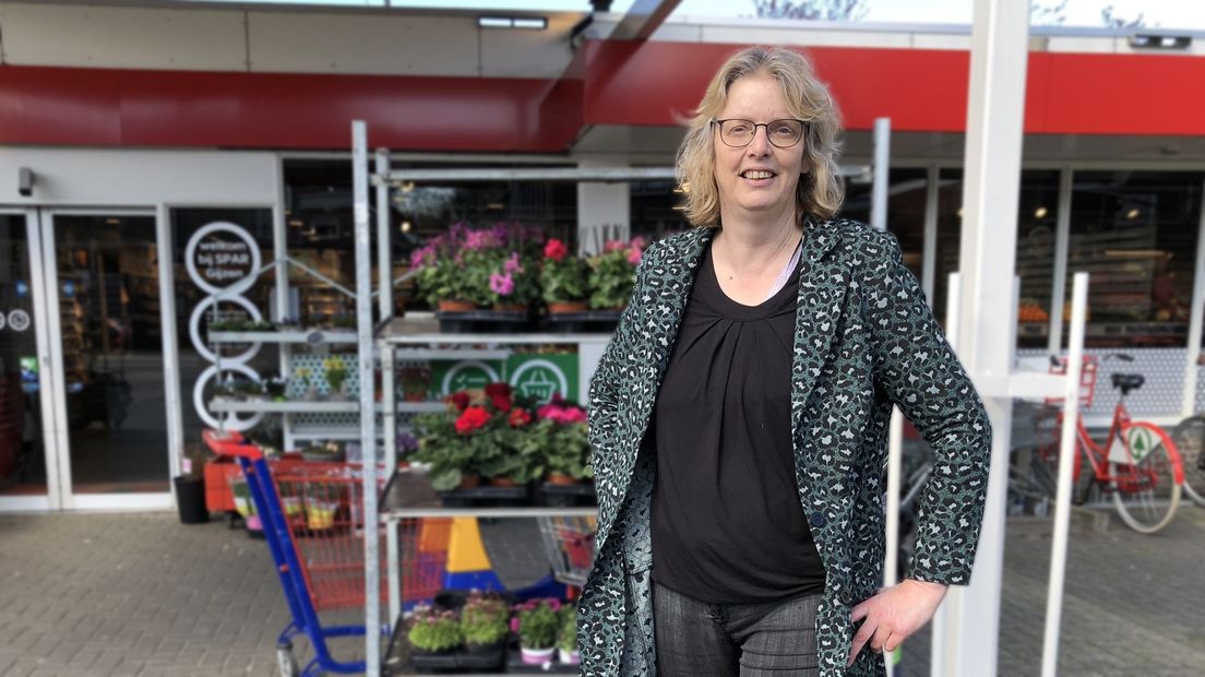 Nannet Gijzen voor de deur van haar supermarkt