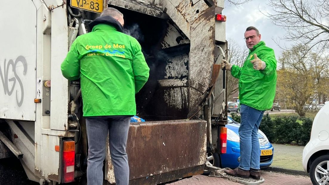 Richard de Mos van Hart voor Den Haag achterop een vuilniswagen