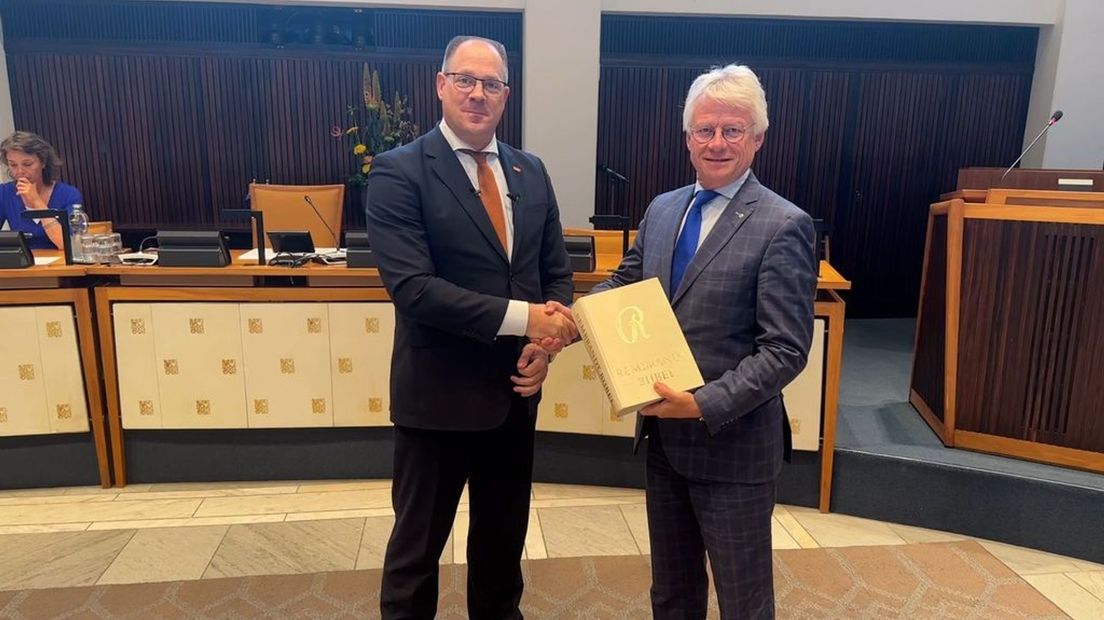 Gerrit Averesch (rechts), geeft de Rembrandt-bijbel aan John Berends