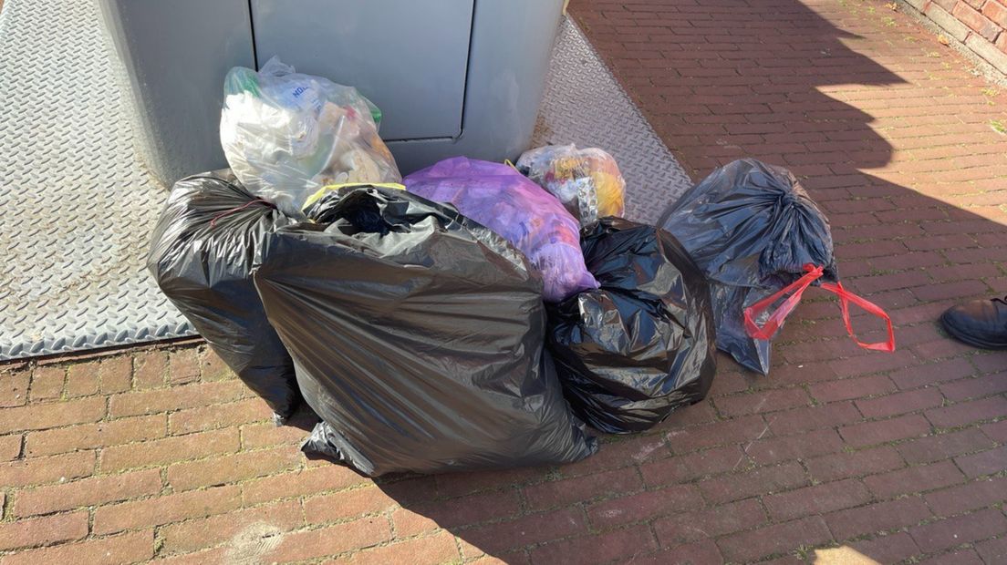 Vuilniszakken naast de ondergrondse afvalcontainer