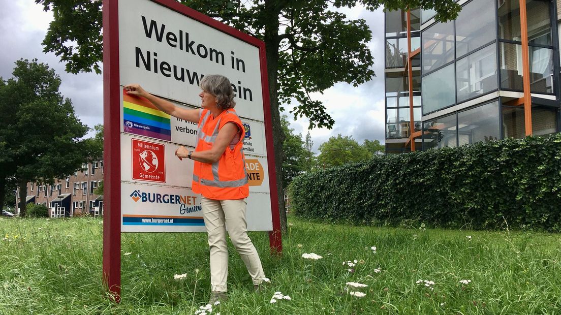 Wethouder Marieke Schouten plakt een regenboogsticker over Pulawy.
