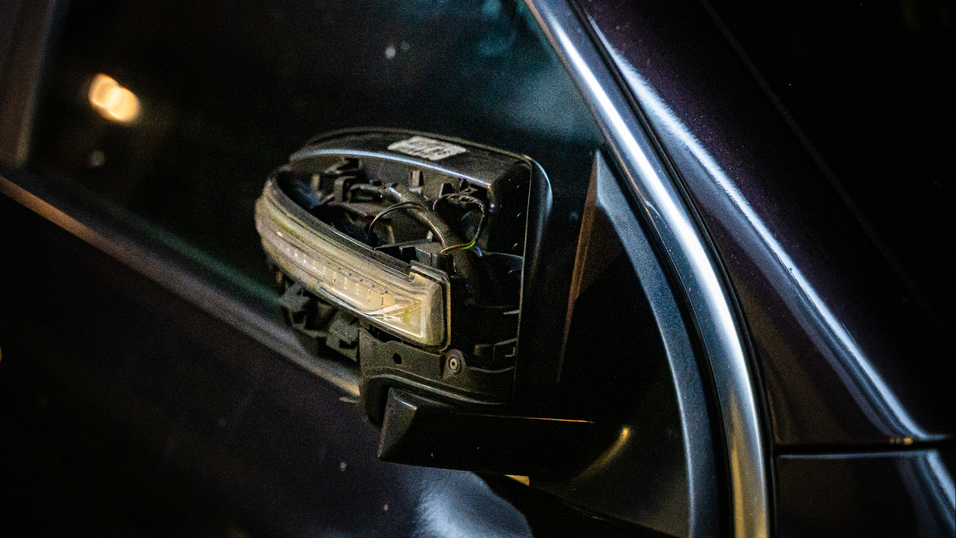 De zijspiegel van een geparkeerde auto is beschadigd door de ontploffing.