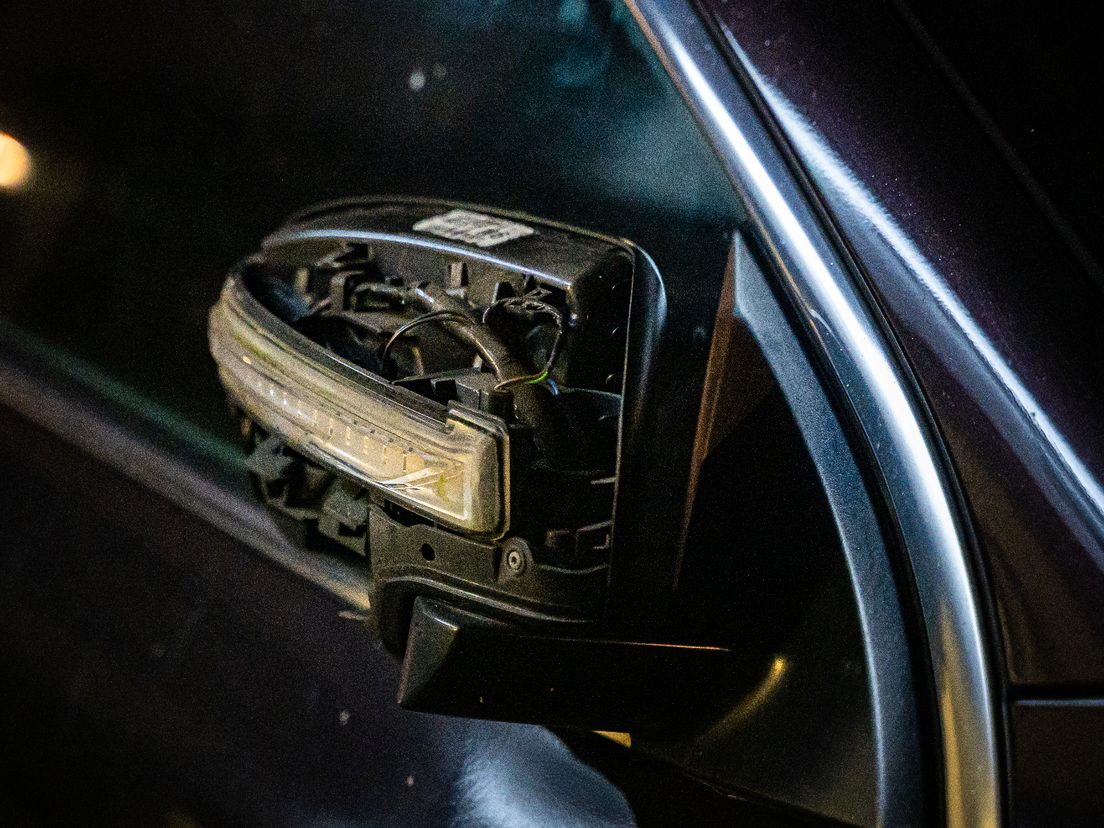 De zijspiegel van een geparkeerde auto is beschadigd door de ontploffing.