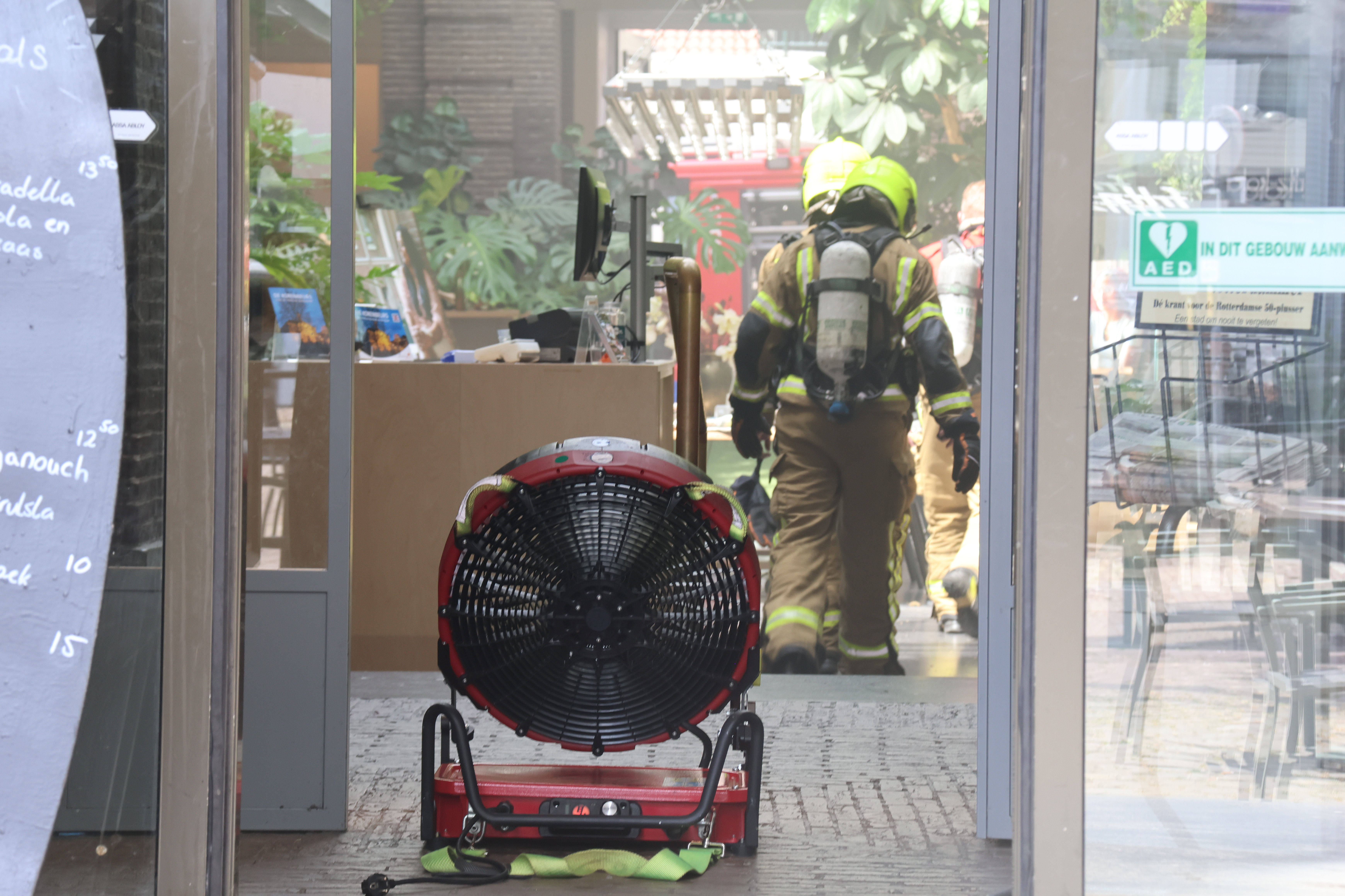 Met ventilatoren probeert de brandweer de rook uit het gebouw te verdrijven.