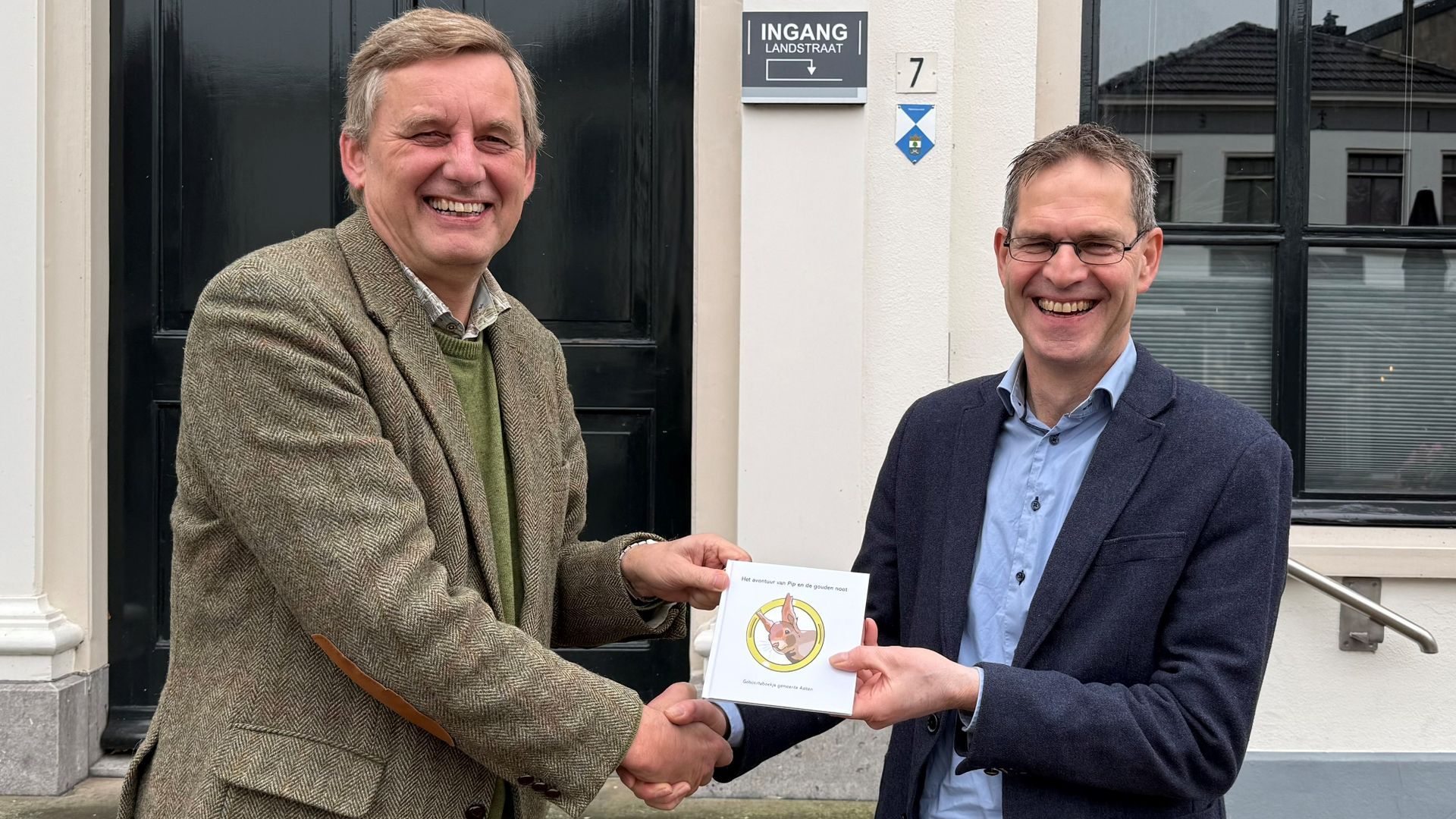 Burgemeester Anton Stapelkamp (links) overhandigt het eerste exemplaar aan Arjan Klein Nibbelink (rechts).