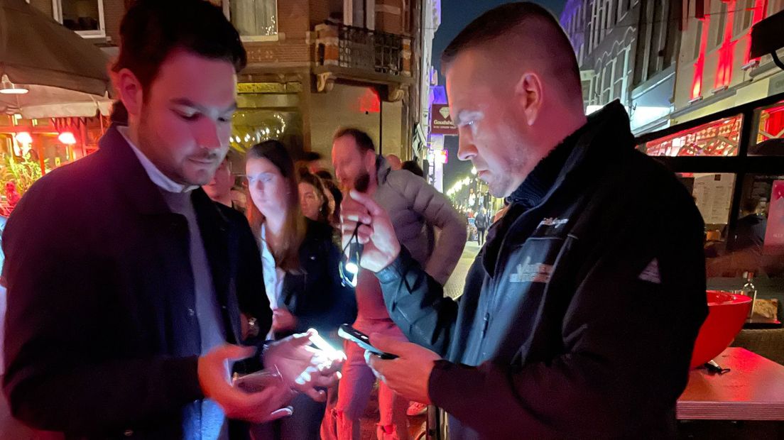 Een beveiliger controleert een coronapas I