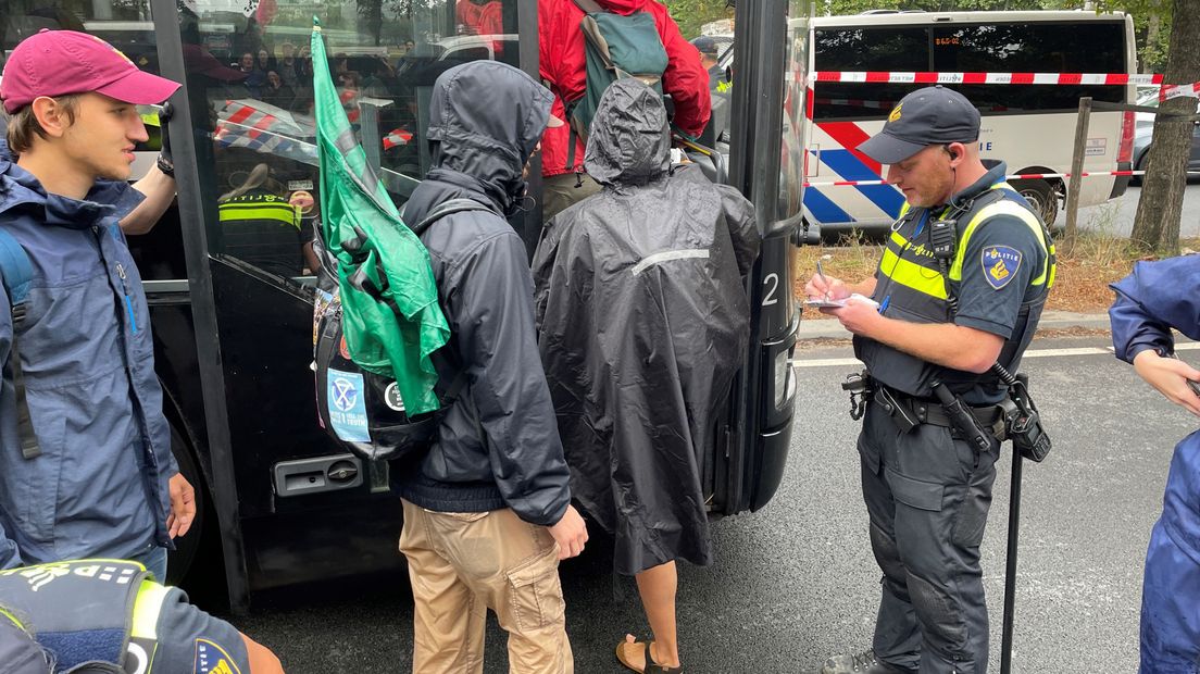 Een agent houdt bij hoeveel demonstranten de bus instappen