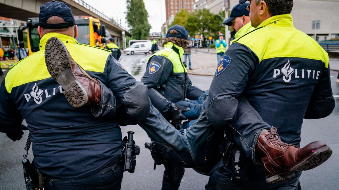 Een demonstrant wordt door de politie weggehaald