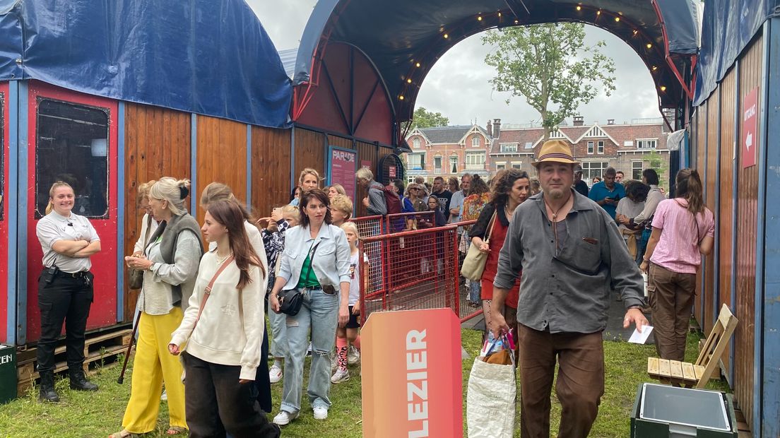 De eerste bezoekers lopen het festivalterrein op.